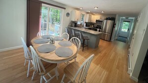 A modern kitchen with a central island, white cabinetry, and stainless steel appliances. - 3BR Coastal Retreat ON Cape Cod Rail Trail near Nauset Light & Coast Guard Beach (Eastham)