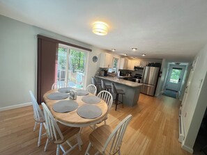 Una cocina moderna con una isla central, muebles blancos y electrodomésticos de acero inoxidable.
