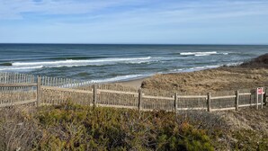 A beach with a wooden fence, ocean waves, and a clear sky. - 3BR Coastal Retreat ON Cape Cod Rail Trail near Nauset Light & Coast Guard Beach (Eastham)