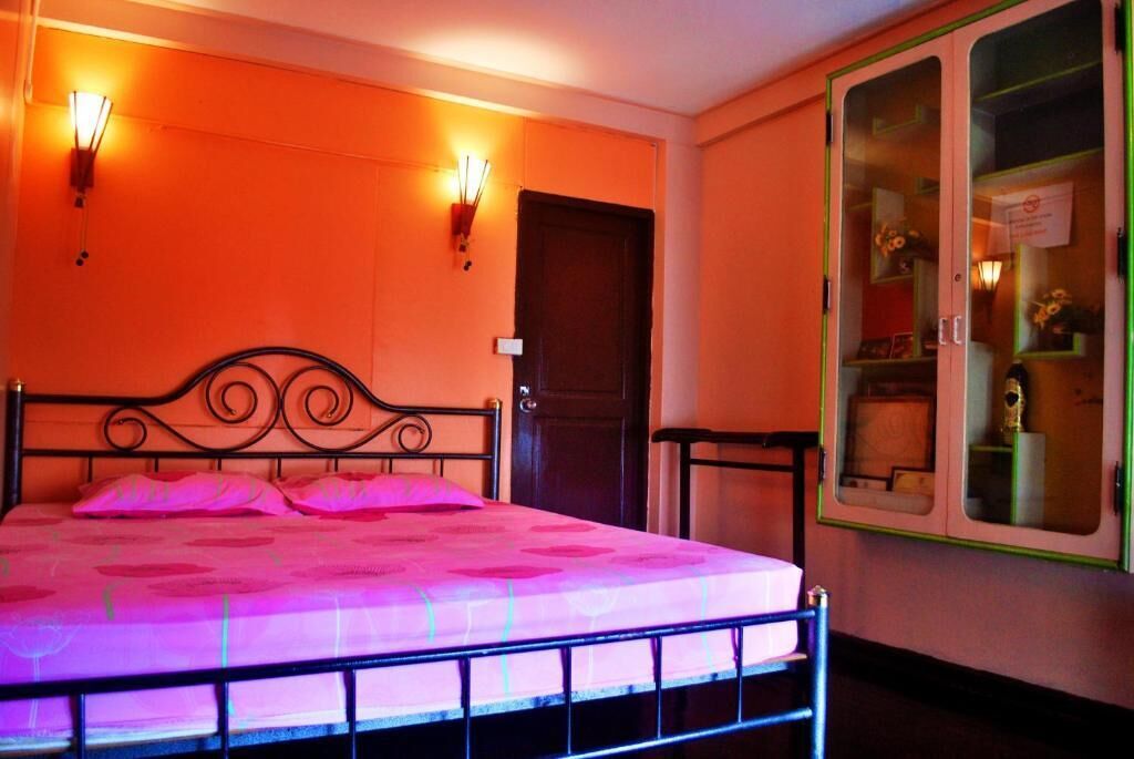 Une pièce avec un lit, une porte et un meuble avec des portes en verre.