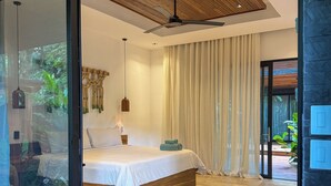 A modern bedroom with a large bed, wooden ceiling, and a view through a glass door. - Kaia Bungalow – Adults Only Private Pool (Manzanillo)