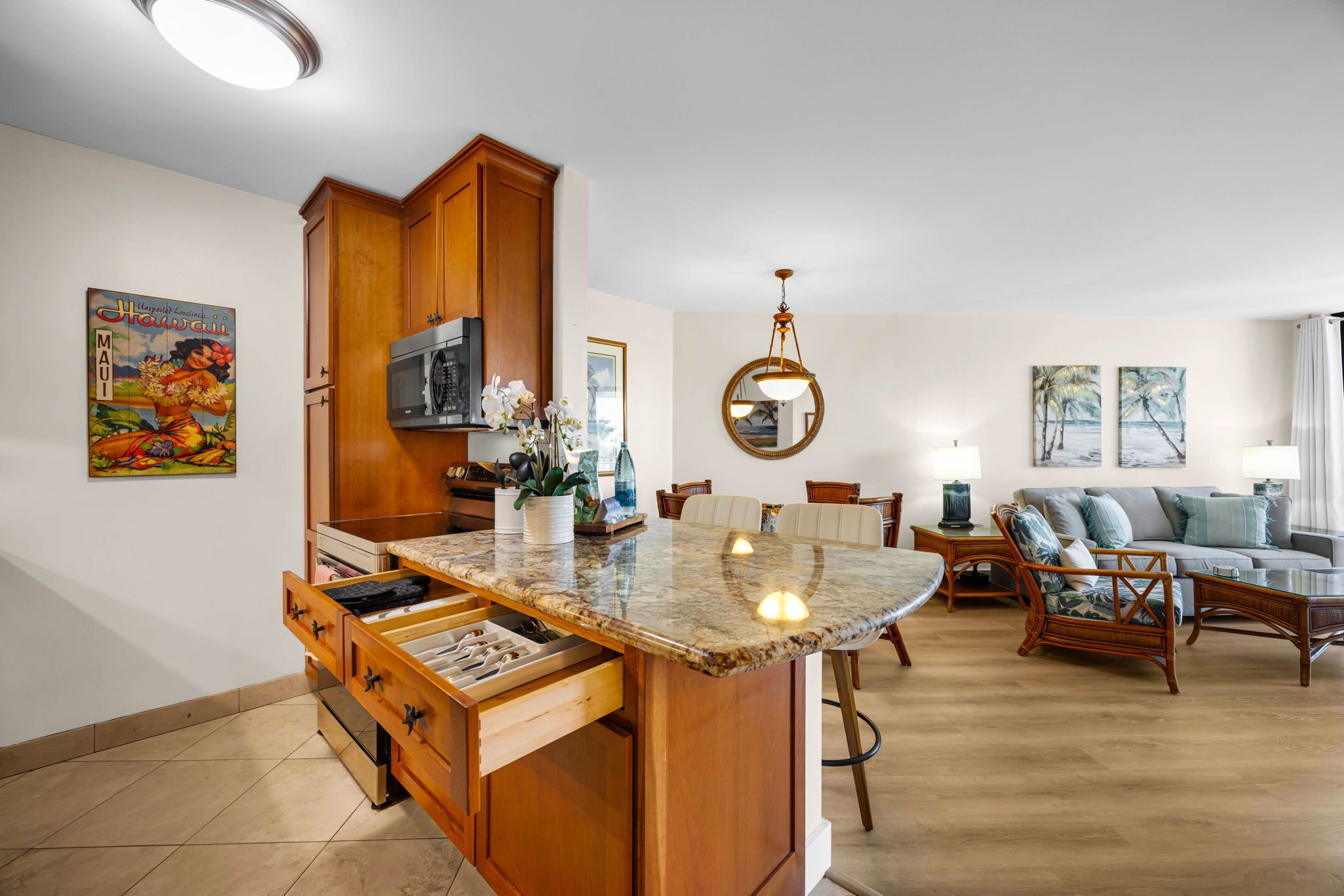 A kitchen with wooden cabinets, a microwave, and a marble countertop.