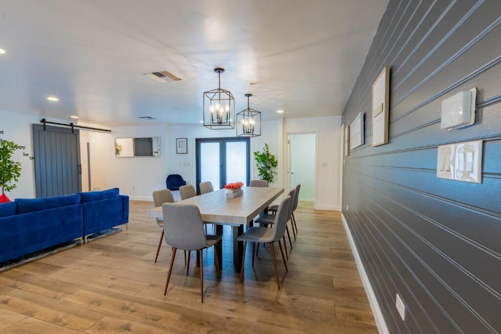 Een modern interieur met een eethoek, een blauwe bank en een groot raam.