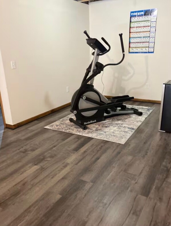 A stationary bike in a room with wooden flooring and a rug. - TURKEY CROSSING ON FAWN
3 Bedrooms and 2 Bath Country Home. (Abilene)