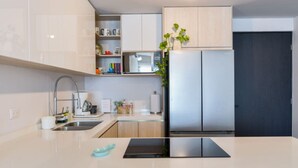 Een moderne keuken met een roestvrijstalen koelkast, een inbouwoven en een spoelbak.