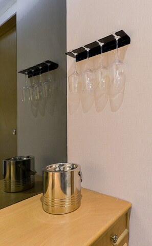 A bathroom with a mirror, a sink, and a shelf holding wine glasses. - Suite Rubí Red Room | Prime Location in Centrito Valle (San Pedro Garza García)