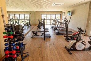 Ein Fitnessstudio mit Krafttrainingsgeräten, Laufbändern und Ergometer.