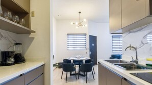 Cozinha moderna com área de jantar, liquidificador embutido e lustre.