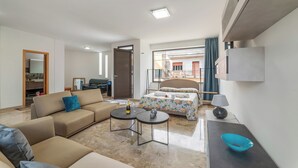 A modern hotel room with a sofa, a bed with a floral duvet, a small table with a bottle and glasses, and a view of the outside. - VillaMar Salento Room 3 With Pool, Cursi, Italy (Cursi)