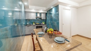 Una cocina moderna con encimeras de granito, electrodomésticos de acero inoxidable y un comedor con salpicadero de mármol.