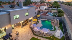 A residential property with a swimming pool, outdoor seating, and a view of the neighborhood. - Luxe Pickleball Villa by Glam Homes (Scottsdale)