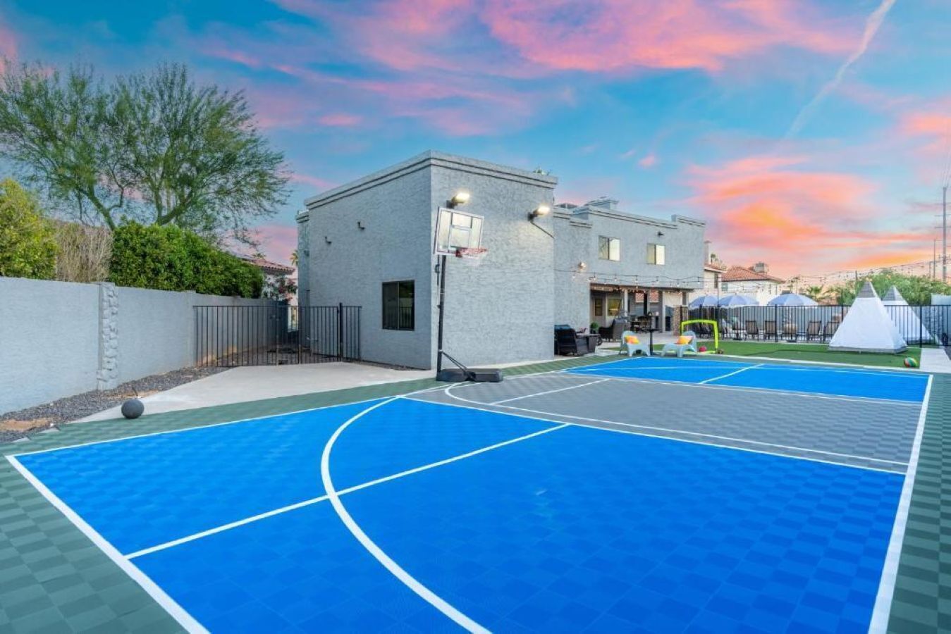 Una cancha de baloncesto al aire libre con un edificio en el fondo.