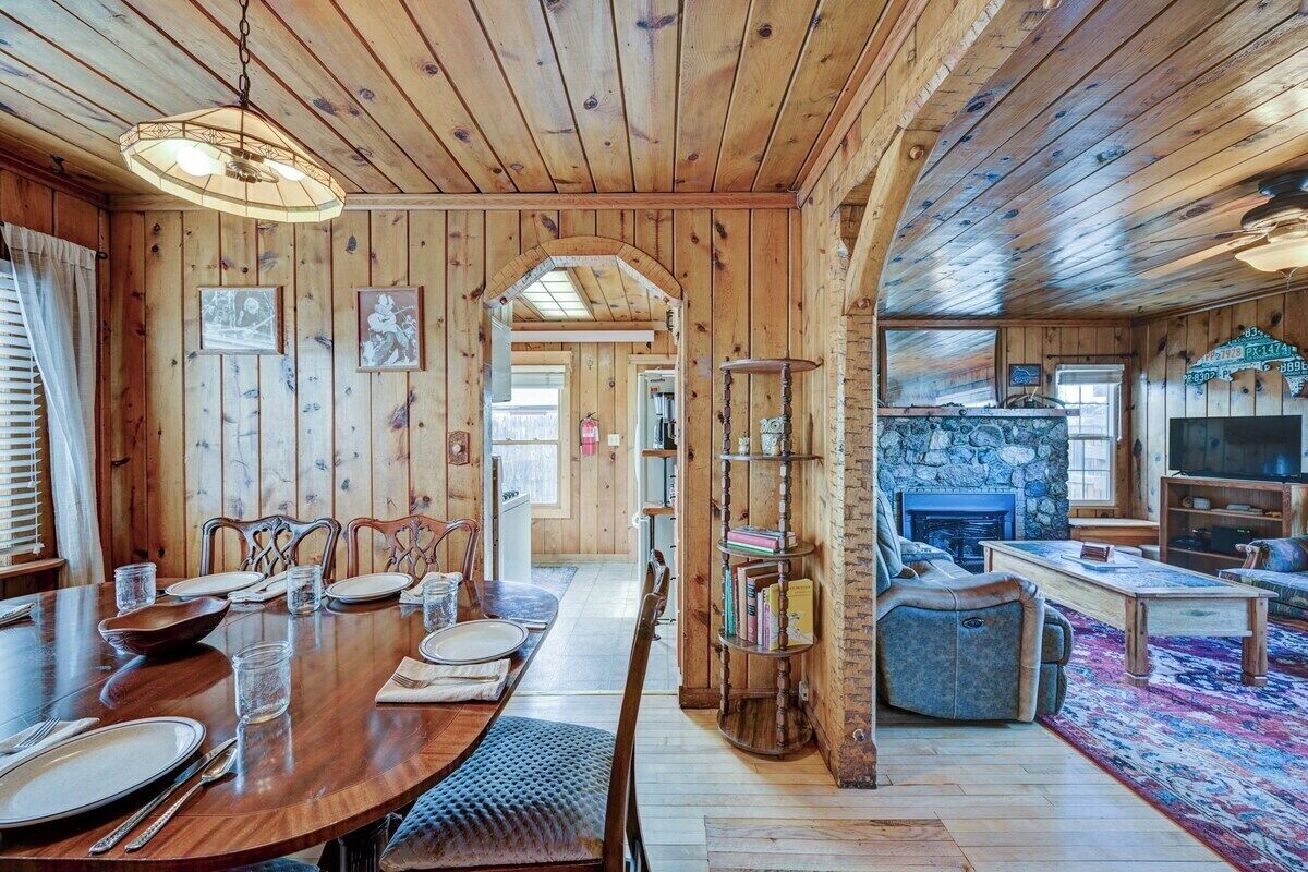 Un intérieur en bois comprenant un coin repas, une cheminée et un salon.