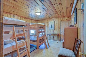 Eine Hütte mit Etagenbetten, einem Schreibtisch und einem Stuhl.