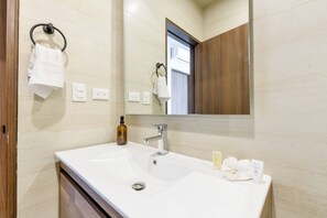 A bathroom with a white sink, a mirror, a towel rack, and a bottle of soap. - ¡Luxury in San Jeronimo! 1 King & 2 Queen Bed 8ppl (Monterrey)