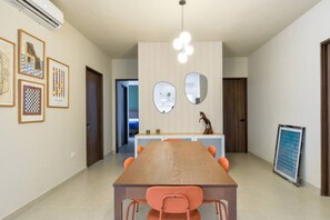 A modern dining area with a wooden table and orange chairs, a whiteboard, and framed artwork on the walls. - ¡Luxury in San Jeronimo! 1 King & 2 Queen Bed 8ppl (Monterrey)