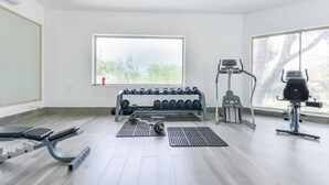 A gym with exercise equipment, a bench, and a window with a view of trees. - ¡Luxury in Santa Catarina! King bed + Wifi | 5 ppl (Santa Catarina)
