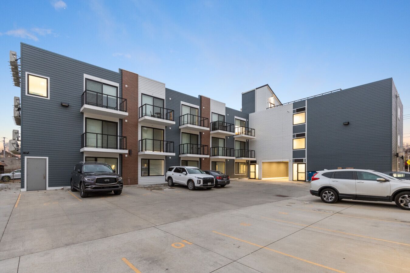 Un immeuble d’appartements à plusieurs étages avec un parking.