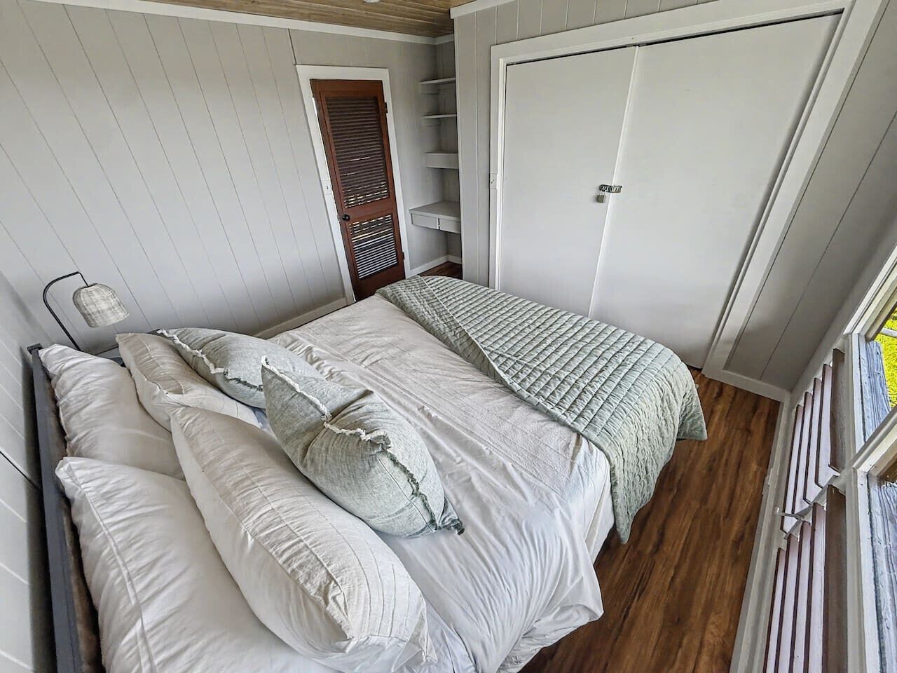 Una camera da letto con un letto, un armadio e una porta.