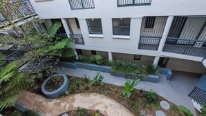 A multi-level courtyard with a central circular pathway, surrounded by planters and greenery. - Chippendale Charmer in Ideal Location (Chippendale)