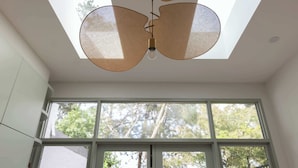 Una habitación con tragaluces, ventanas amplias y una lámpara colgante.