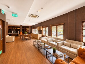 A spacious lobby with a dining area, sofas, and a kitchen in the background. - Bugis Social- Newly Renovated (Singapore)