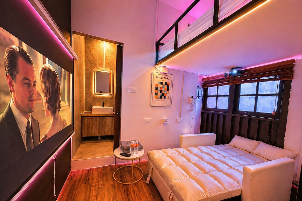 Un dormitorio moderno con cama, una mesita, un baño con lavamanos y un ventanal.