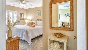 A bedroom with a bed, a bedside table, a mirror, and a ceiling fan. - Direct Beach Access, Views, Heated Pool, Hot Tubs, Tennis, Walk to Restaurants, $300 in Free Tickets (St. Augustine)