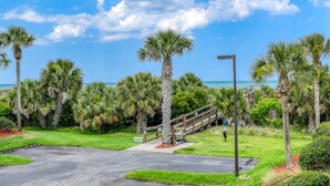 A paved pathway leading to a wooden staircase, surrounded by palm trees and a clear blue sky. - Direct Beach Access, Views, Heated Pool, Hot Tubs, Tennis, Walk to Restaurants, $300 in Free Tickets (St. Augustine)