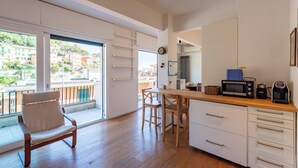 Una cocina con encimera de madera, armarios blancos, microondas y cafetera.