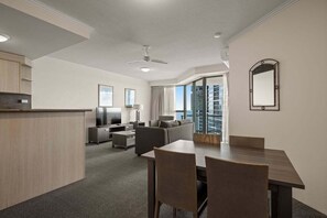 A hotel room with a dining area, a sofa, a TV, and a balcony with a view. - Coastal View Haven with Balcony (Gold Coast)