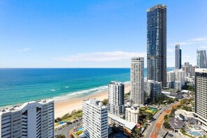A coastal cityscape with high-rise buildings, a beach, and a clear blue sky. - Coastal View Haven with Balcony (Gold Coast)