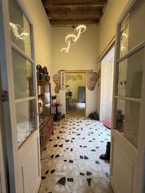 A hallway with a tiled floor, wooden furniture, and a neon light. - CASA BO | LOFT IN THE HEART OF MEXICO CITY (Ciudad de México)