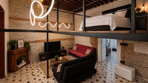 A loft-style room with a bed, sofa, TV, fireplace, and a neon light. - CASA BO | LOFT IN THE HEART OF MEXICO CITY (Ciudad de México)