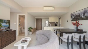 A modern living room with a sofa, coffee table, and TV. A dining area with a table and chairs is visible. A kitchen with cabinets and appliances is in the background. - Nice stay next to Thao Dien area, 3brs, 5min to MRT, central (Thành phố Hồ Chí Minh)