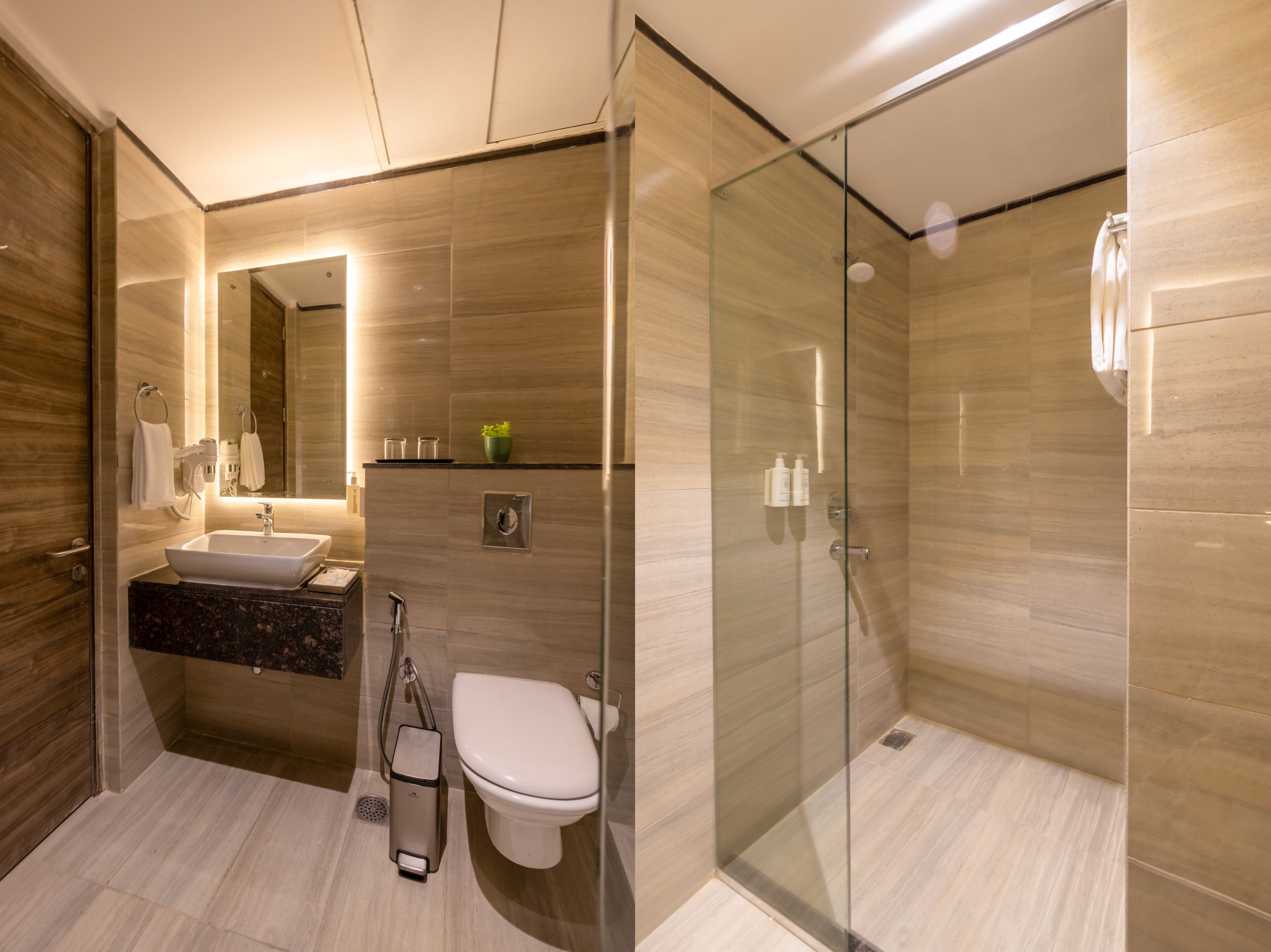 A modern bathroom with a glass shower enclosure, a sink with a marble countertop, and a toilet.