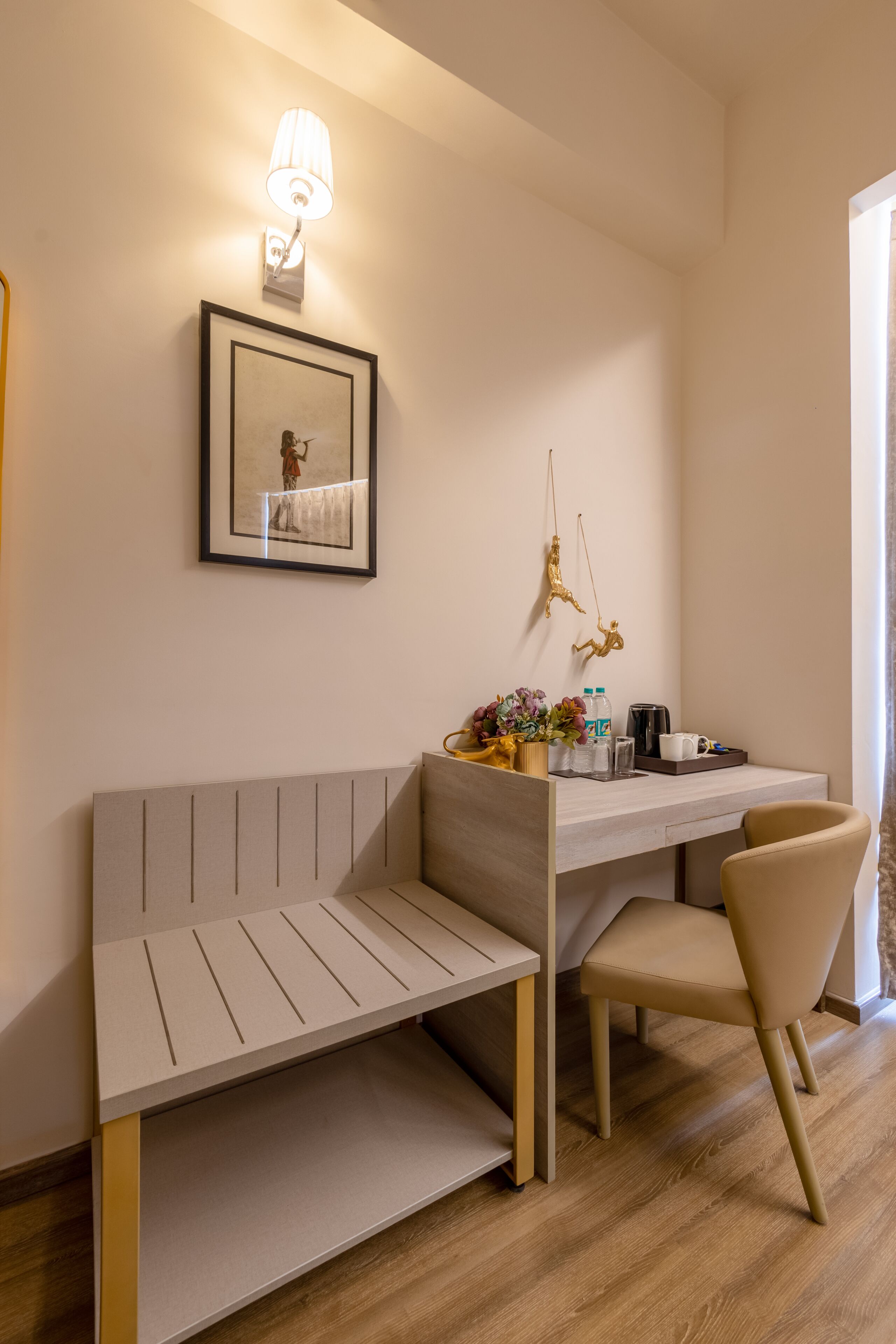 Une chambre moderne équipée d’un bureau, d’une chaise, d’un banc et d’un tableau encadré au mur.