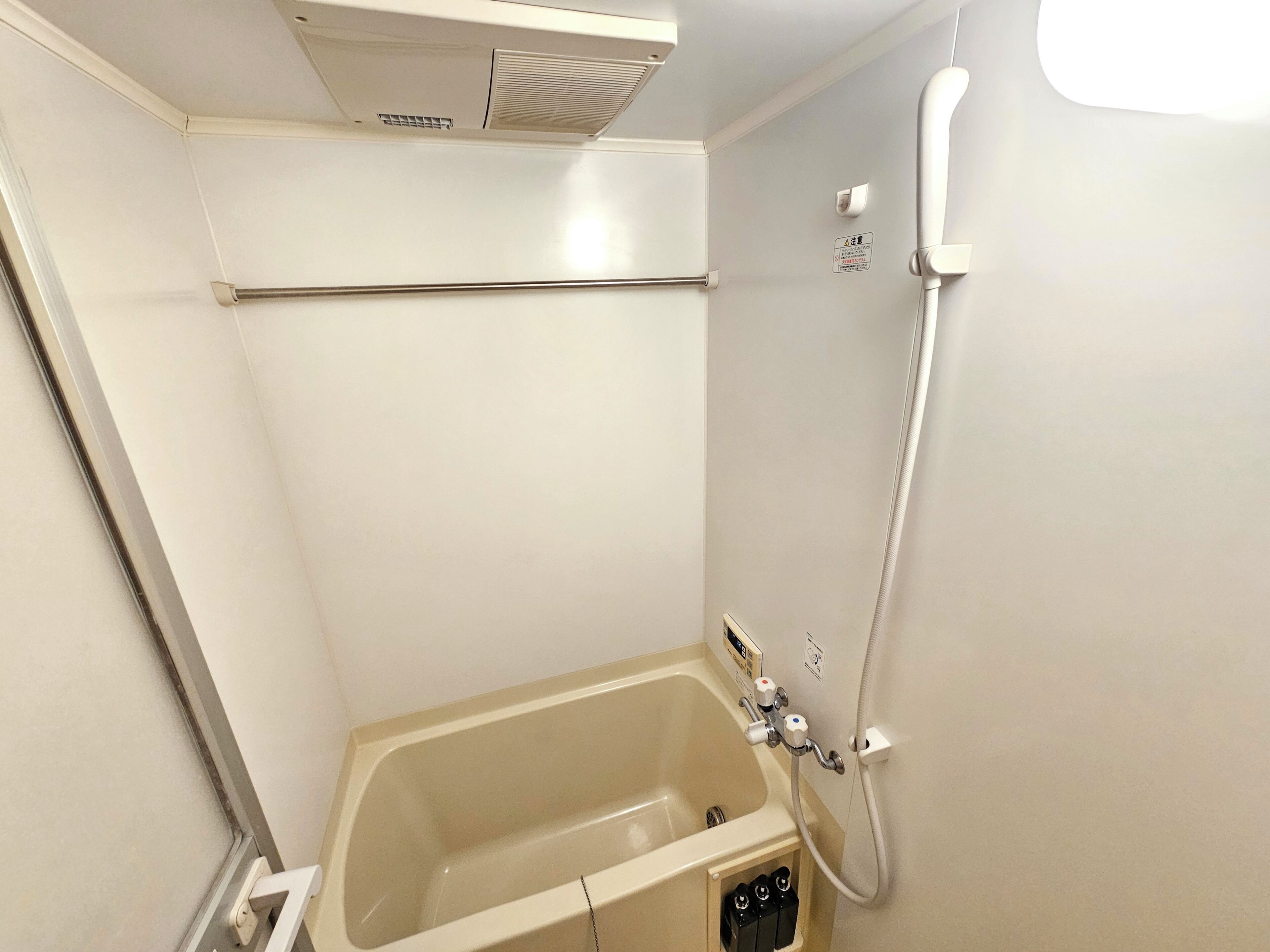 Ein kleines, separates Badezimmer mit Badewanne, Dusche und einem Händetrockner.