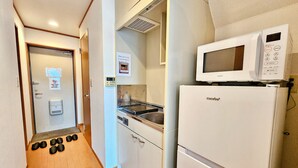 A compact kitchen with a microwave, a coffee machine, and a sink. - Gold Mansion Apartments (Tokyo)