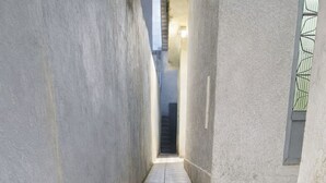 A narrow stairway with stone steps leading to a door at the end.