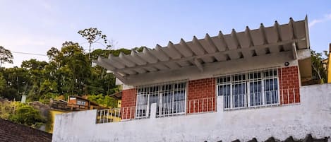 Una casa de dos pisos con un balcón, un porche cubierto y un garaje.