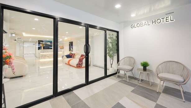 A hotel reception area with a glass door, a reception desk, and seating arrangements. - Global Hotel Pratunam Bangkok (Bangkok)