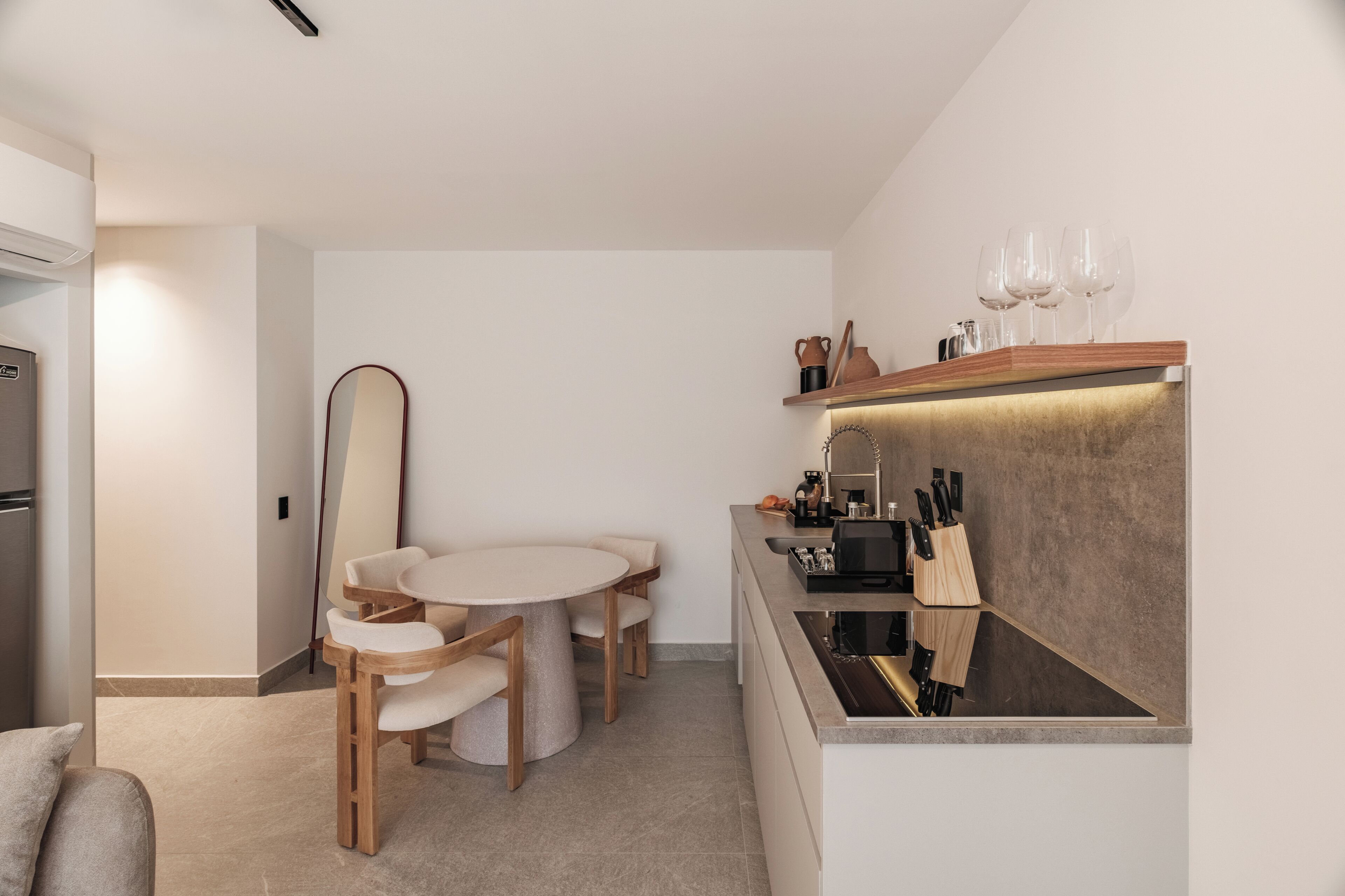 Una cocina moderna con comedor, electrodomésticos integrados y una encimera con cuchillos.