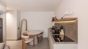 Una cocina moderna con comedor, electrodomésticos integrados y una encimera con cuchillos.