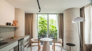 Eine moderne Küche mit Essbereich, großen Fenstern und Blick auf Grünflächen.