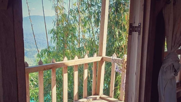 A wooden deck with a view of greenery and mountains. - Nisarga Pod House Kaptai (Rajasthali)