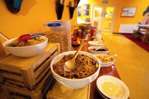 A breakfast buffet with various food items and utensils.