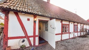 Ein traditionelles Fachwerkhäuschen mit geneigtem Dach, einladendem Eingang und einem kleinen Garten.