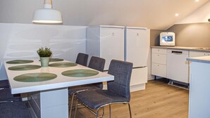 A compact kitchenette with a refrigerator, a microwave, and a small TV.