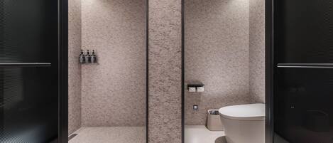 Un bagno moderno con pareti divisorie in vetro, una vasca da bagno freestanding e un box doccia.